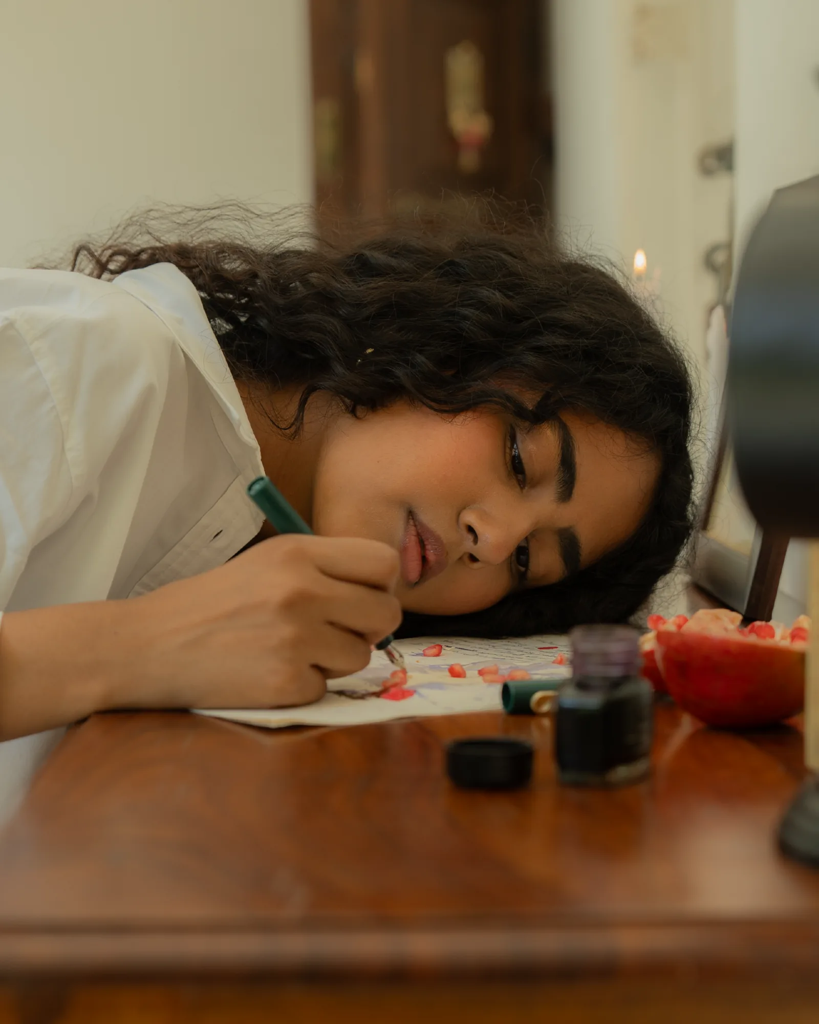 The Mail Room — a correspondence written by hand at the wooden desk, ink and pomegranate beside the paper.